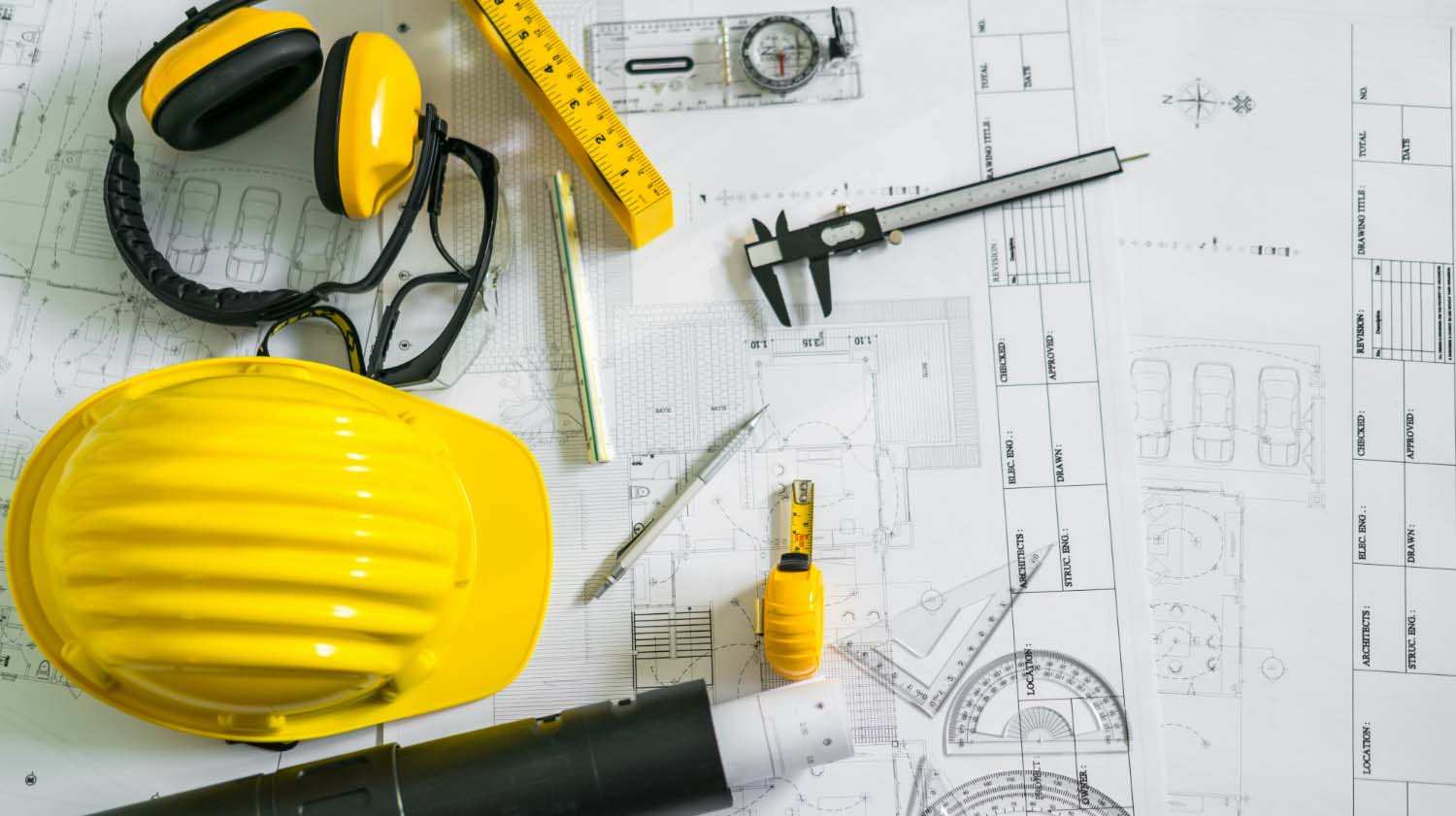construction plans with helmet, and drawing tools,