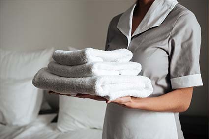 housekeeper holding fresh clean folded tower