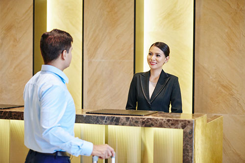 Female reception at reception desk with a guest
