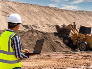 Site Surveyor using a laptop while inspecting at a mining site