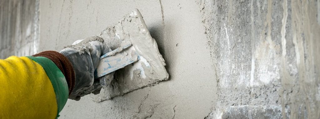 hand worker plastering cement on wall